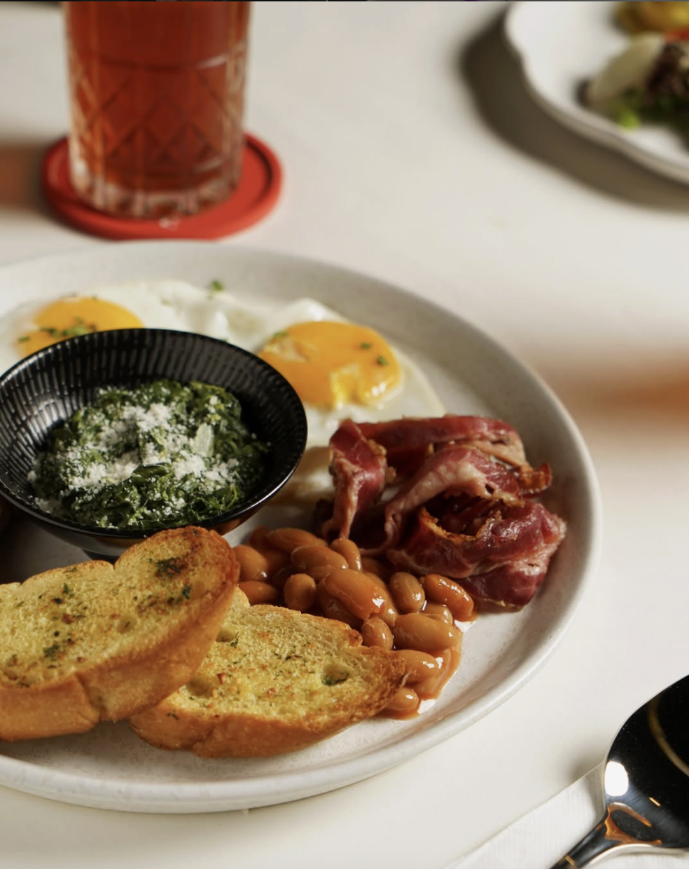 Écoute breakfast platter with eggs, bacon, beans, creamy spinach and garlic toast