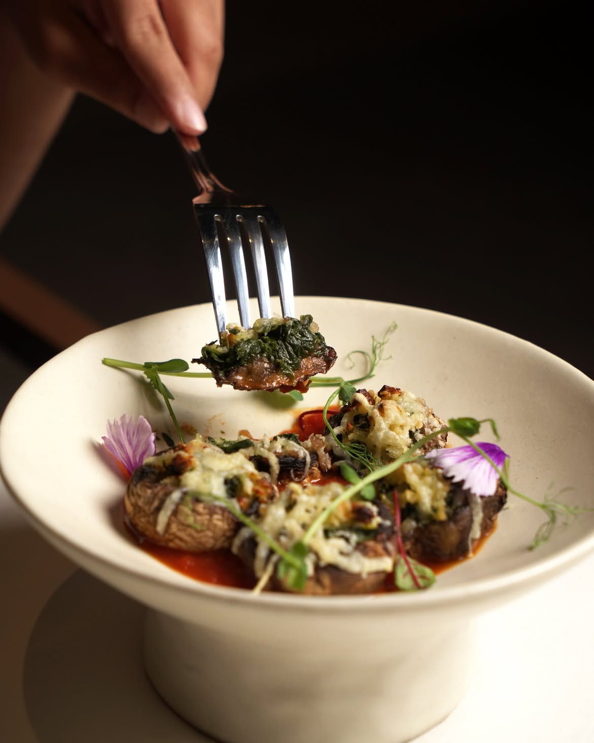 Stuffed mushrooms with melted cheese, herbs and edible flowers